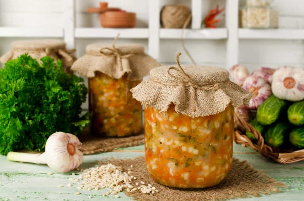 Barley vegetable soup in a jar whose top is covered with burlap and tied with twine.