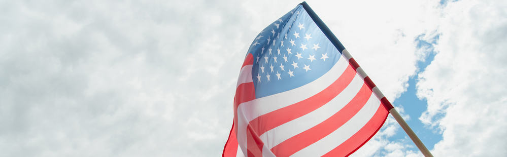 U.S. flag in cloudy sky