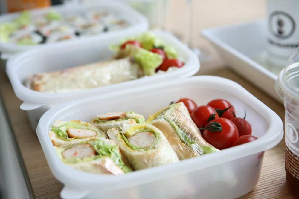 Sandwiches with grapes in plastic boxes.