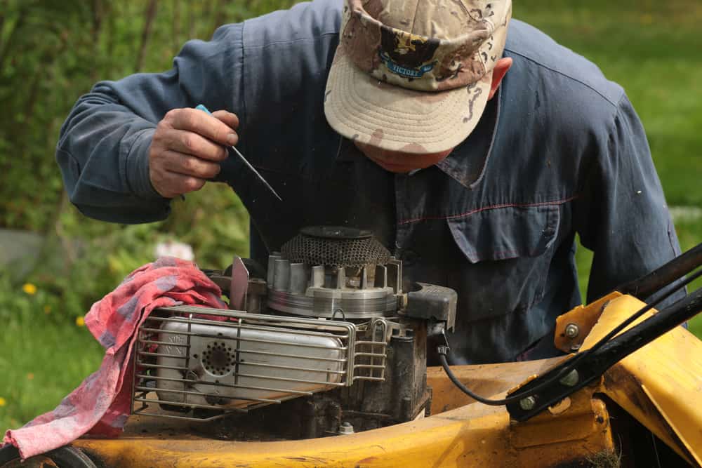 Man repairing a lawn mower.