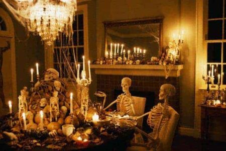 Skeletons at a dining table in a haunted house surrounded by candles