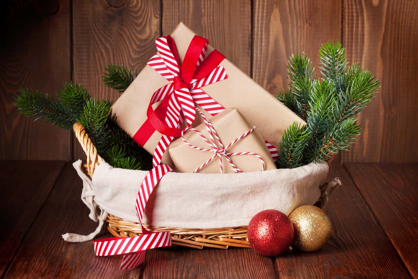 Christmas gifts and tree branch in a basket.