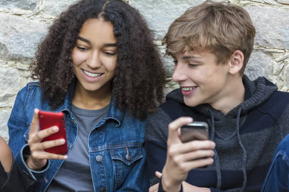 2 teens looking at cellphones