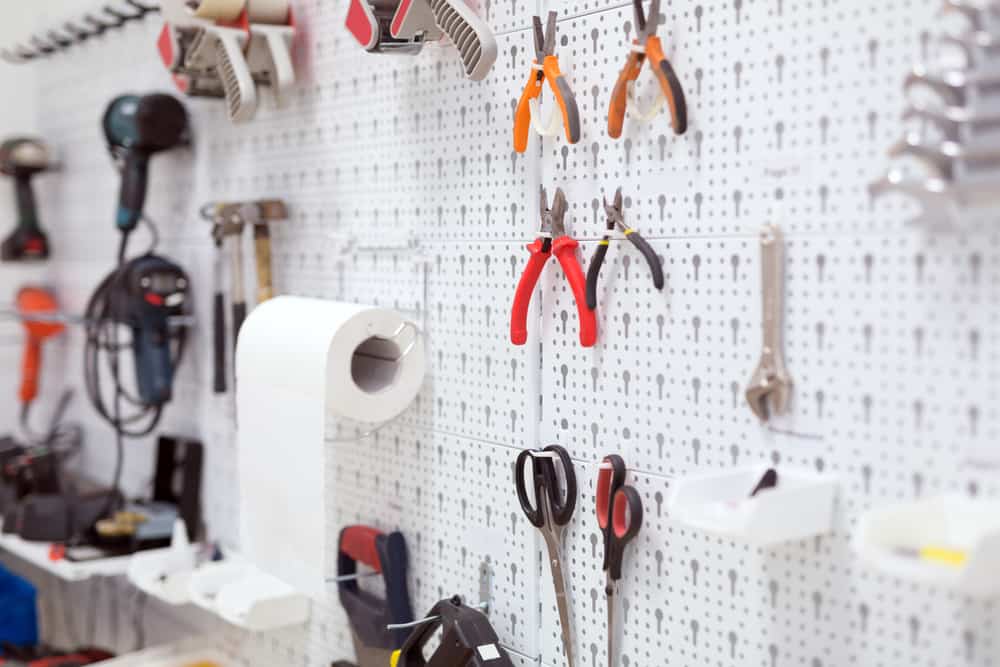 Tools hanging on white pegboard.