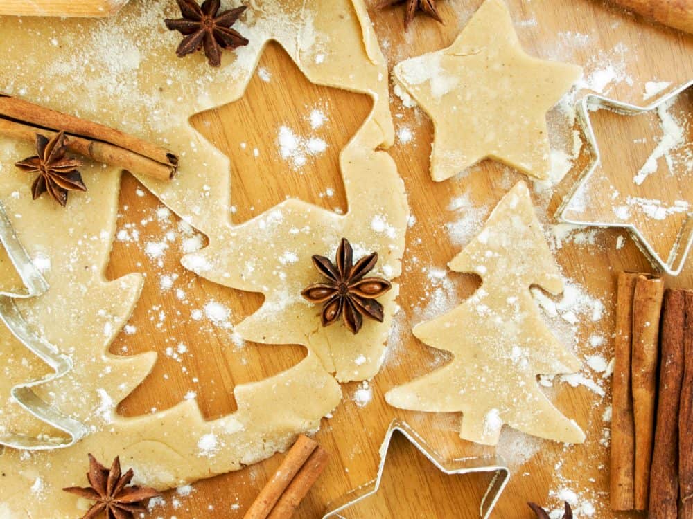 A Christmas tree and a star being cut out of dough. 