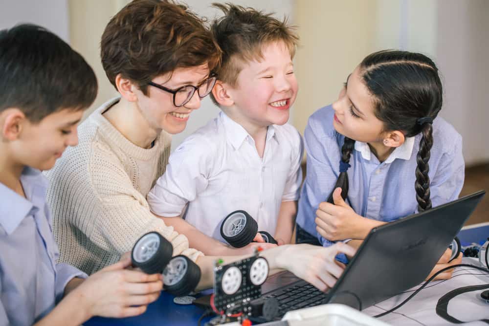 Elementary-school kids gathered around a laptop