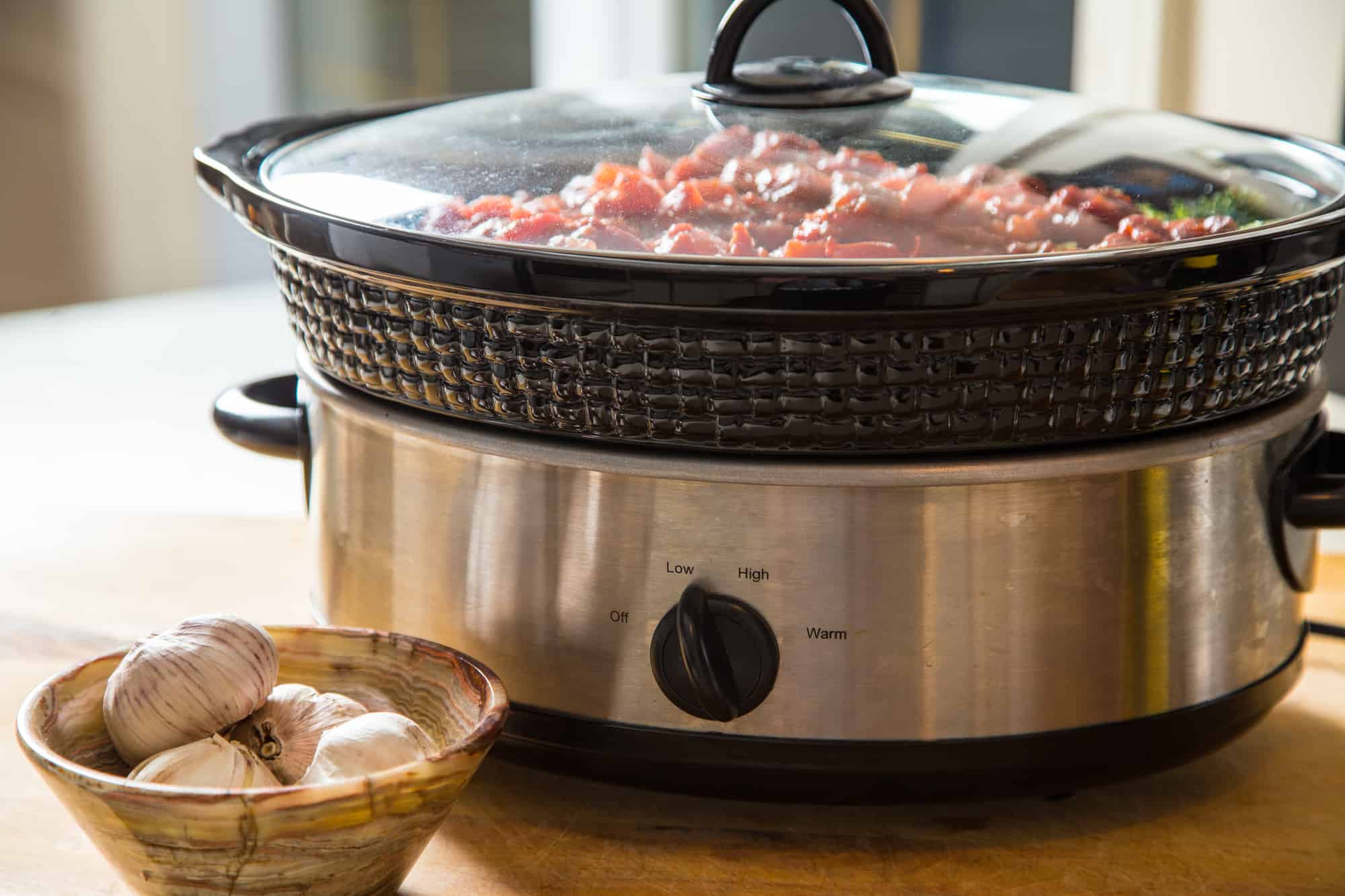 Meal cooking in slow cooker on counter