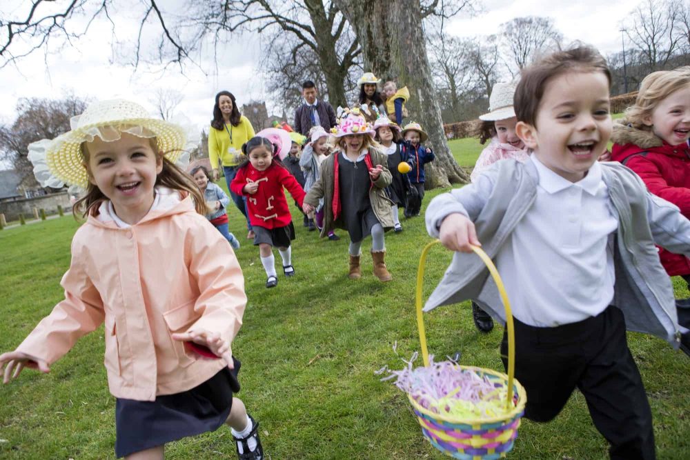 Young children running to find Easter eggs in an Easter egg hunt.