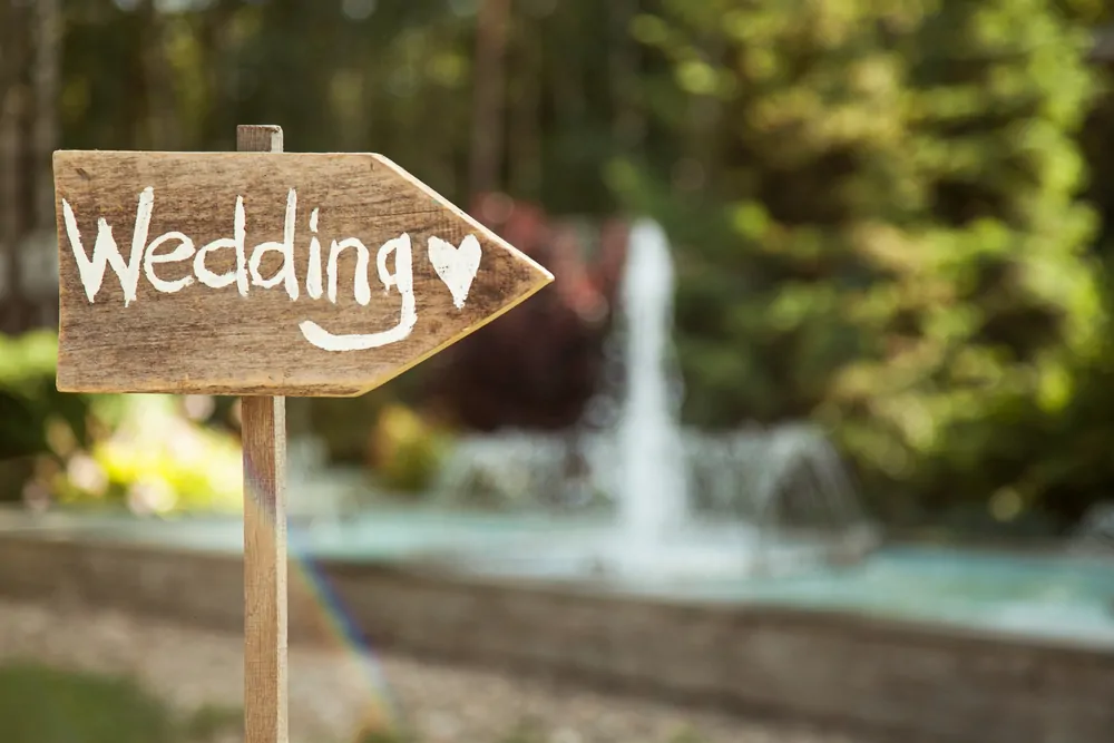 Wooden signpost reading "Wedding" with a heart image.