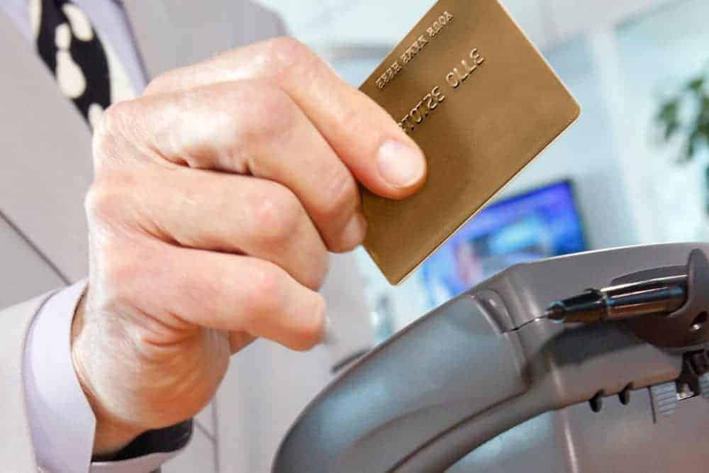 Closeup of man's hand swiping credit card.