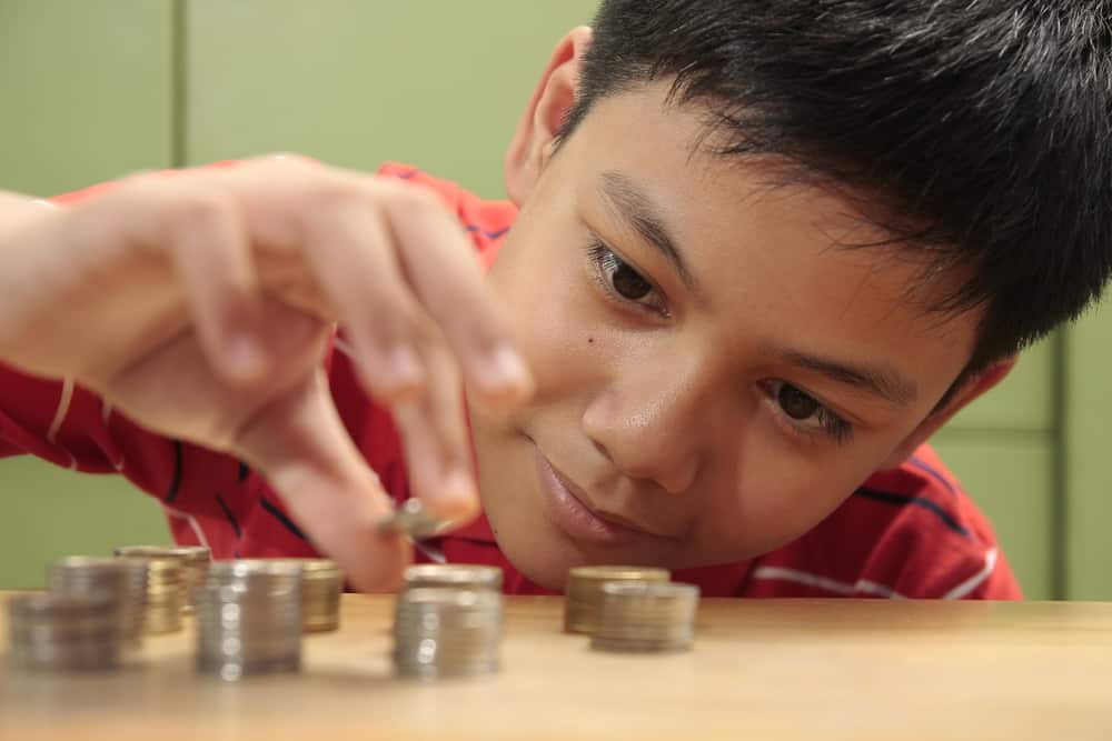Boy stacking coins.