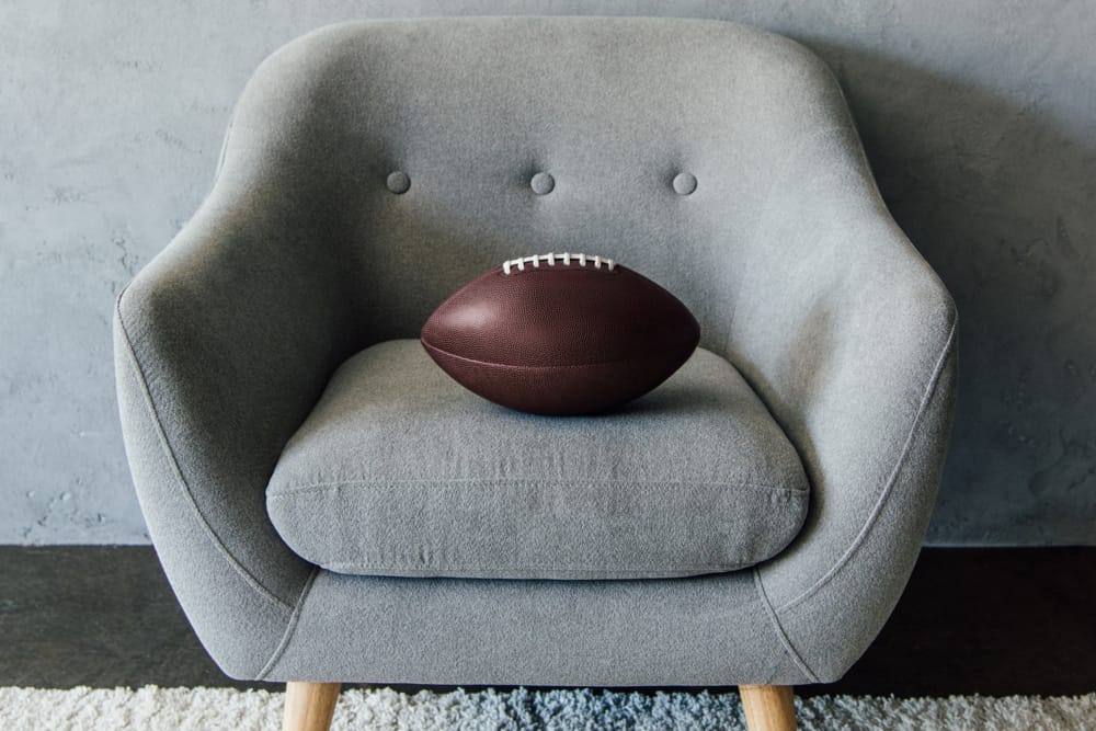 college football sitting on comfy chair
