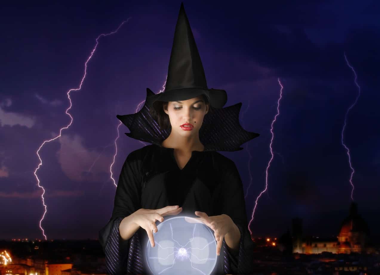 Woman in a witch costume peering into a crystal ball