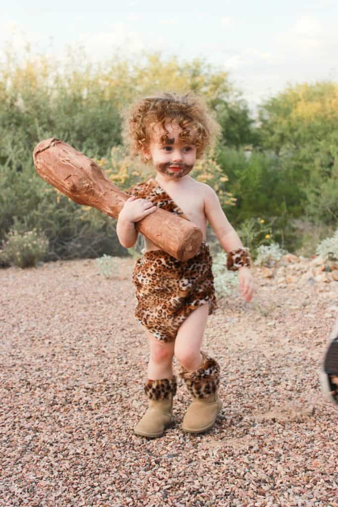 baby dressed up like caveman in animal print and club