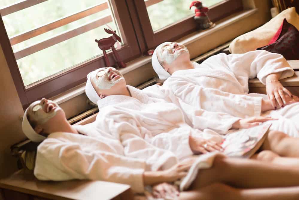Three women relaxing in spa robes.