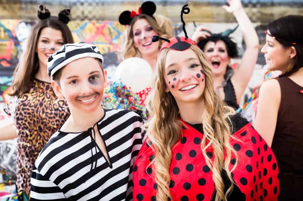 Women dressed for Halloween as a jail inmate and lady bug.