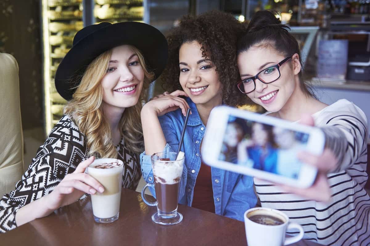 Friends taking a selfie over lattes