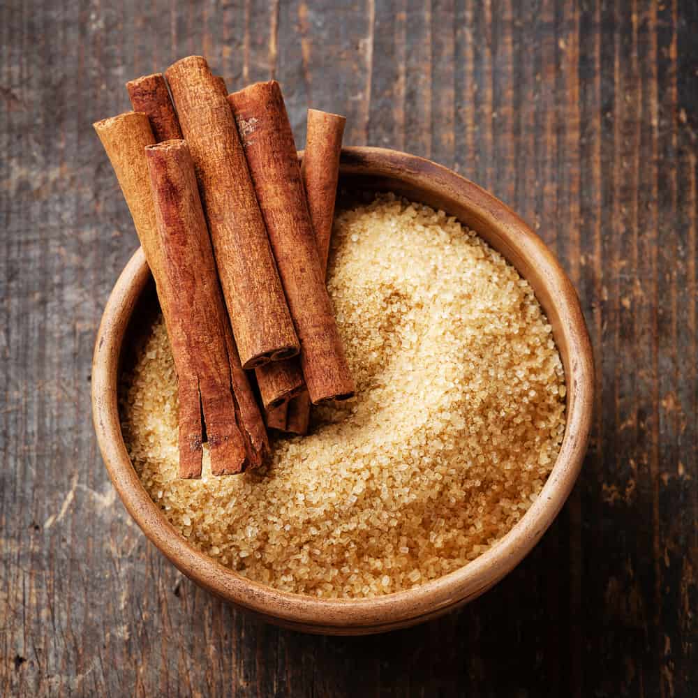 Cinnamon sticks in bowl of brown sugar