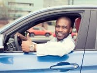 Save money on gas - Black man in blue car giving thumbs up