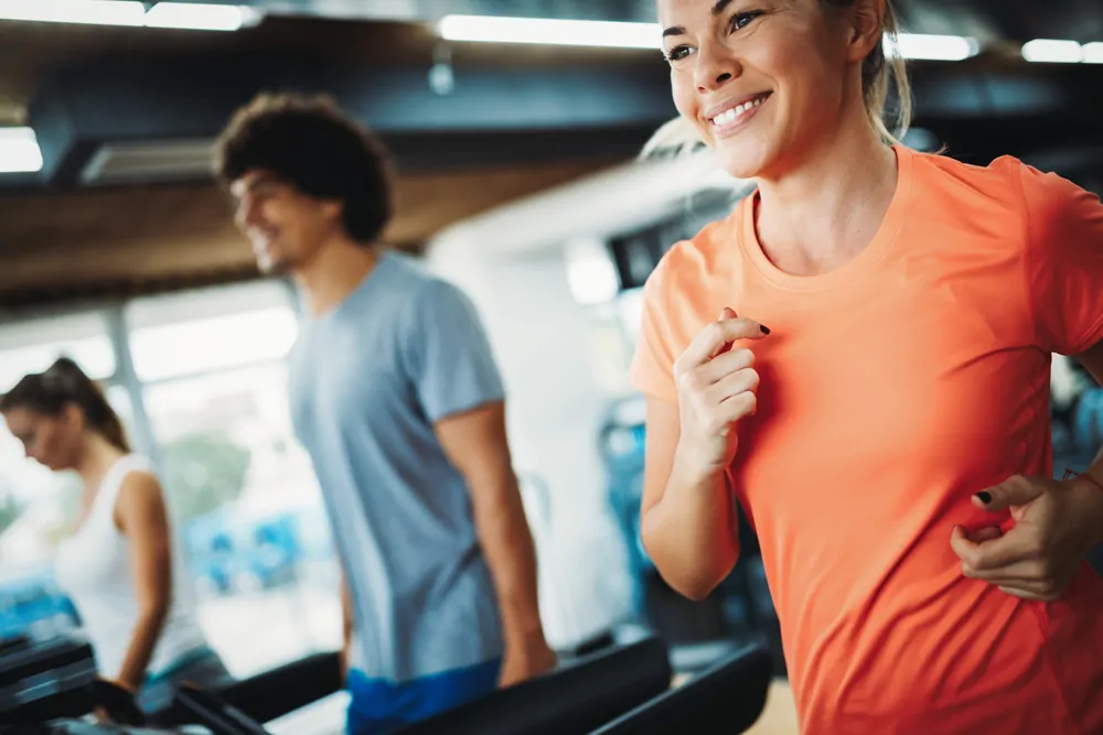 Men and women running in gym.