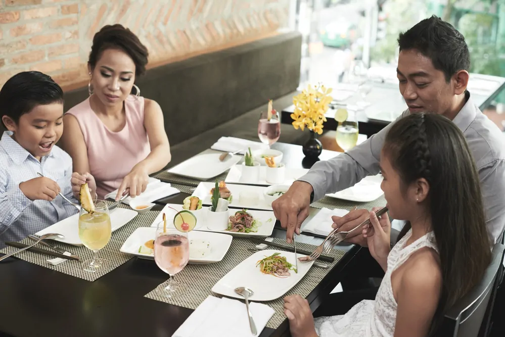 A family of four eating dinner in a restaurant.