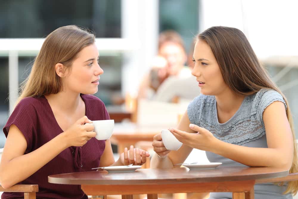 Women talking over coffee in restaurant.