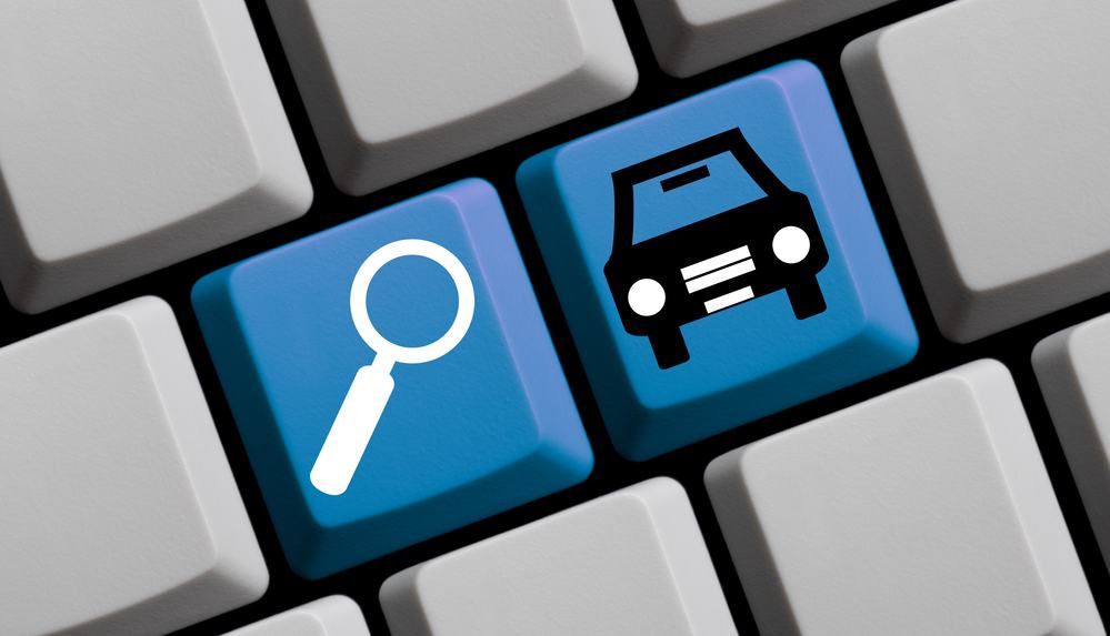 A computer keyboard showing keys with a magnifying glass and a car on them.