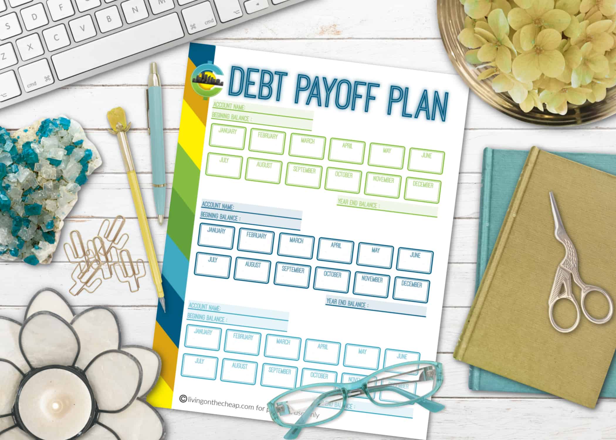 a paper with Debt Payoff Plan written on it with check boxes, next to a computer keyboard and reading glasses
