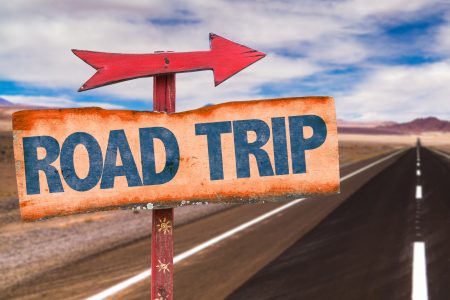 Save money on road trips - empty highway with sign saying road trip and arrow