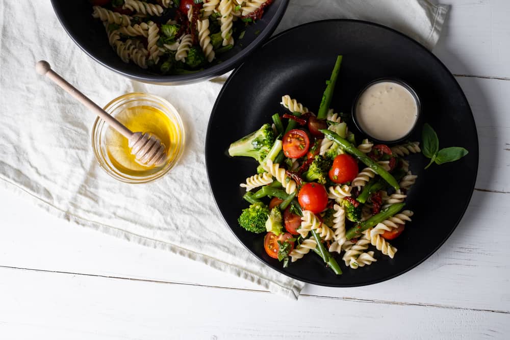 Pasta salad with vegetables in a black bowl