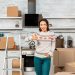 Declutter your home - Woman in kitchen with boxes giving the thumbs up