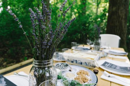 Passover recipes and crafts - purple flowers in a jar at outdoor seder with seder plate and matzah