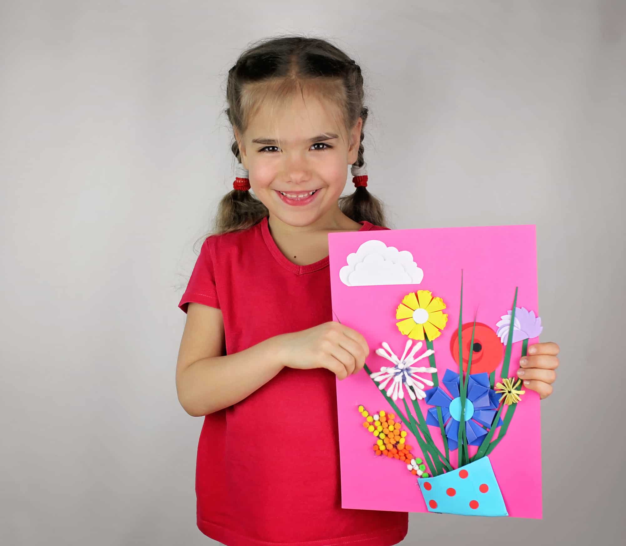 Little girl holding homemade Mother's Day card with paper flowers