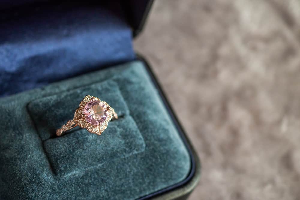 A vintage pink diamond ring in a green velvet box