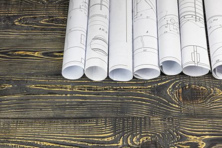 Architect's blueprints rolled up on a wooden table