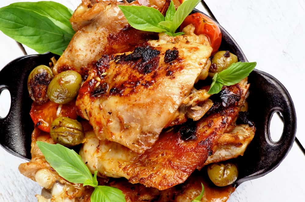 Chicken thighs in cast iron pan with olives