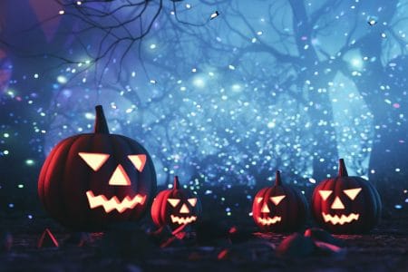 Illustration of jack-o'lanterns in forest withe blue background and white lights.