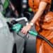Closeup of woman's torso as she fills car with gas.
