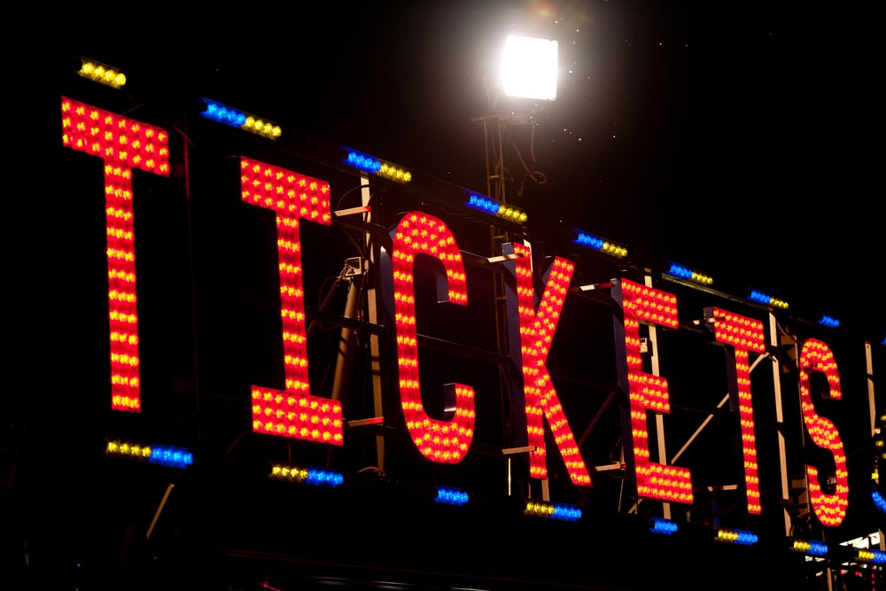 A lighted sign that says TICKETS
