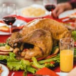 A Thanksgiving turkey on a dining table surrounded by side dishes.